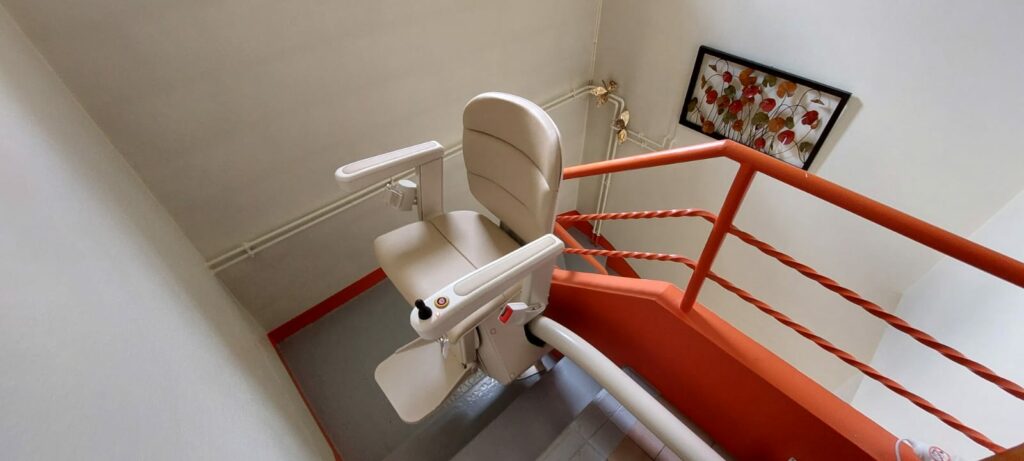 direction de Cluses en Haute-Savoie pour la pose et fourniture d'un monte escalier Handicare France modèle monorail Rembrandt !  Siège Elégance Beige Rail de couleur Gris clair Départ avec un rail relevable électrique afin de ne pas gêner le passage.