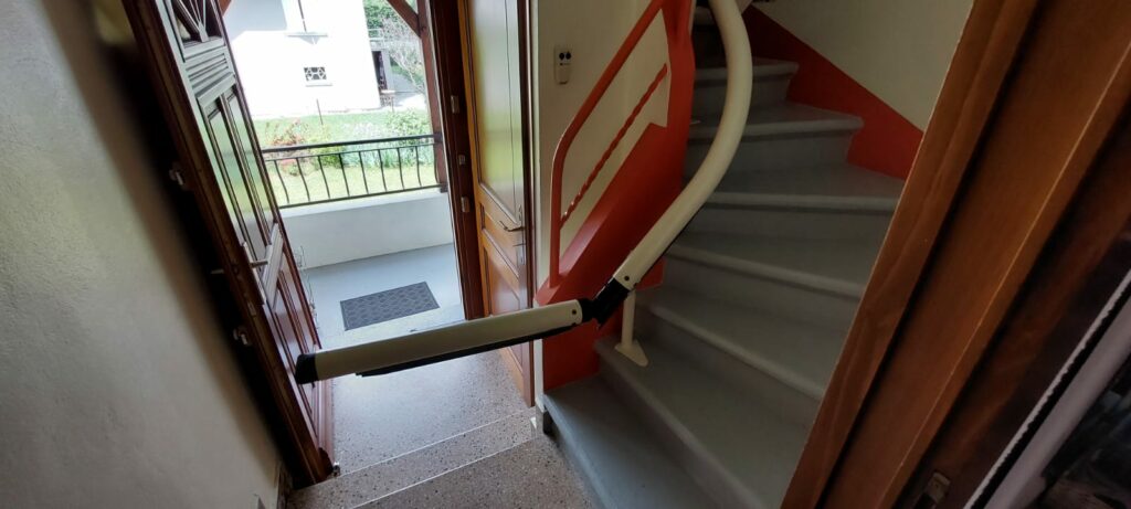 direction de Cluses en Haute-Savoie pour la pose et fourniture d'un monte escalier Handicare France modèle monorail Rembrandt !  Siège Elégance Beige Rail de couleur Gris clair Départ avec un rail relevable électrique afin de ne pas gêner le passage.