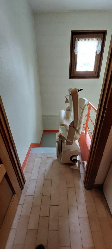 Monte-escalier replié en bas d'escalier rouge et gris près d'une porte d'entrée