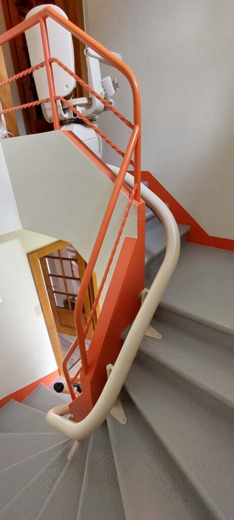 Monte-escalier replié en bas d'escalier rouge et gris près d'une porte d'entrée