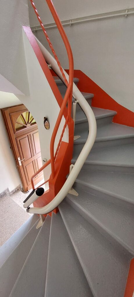 Monte-escalier replié en bas d'escalier rouge et gris près d'une porte d'entrée