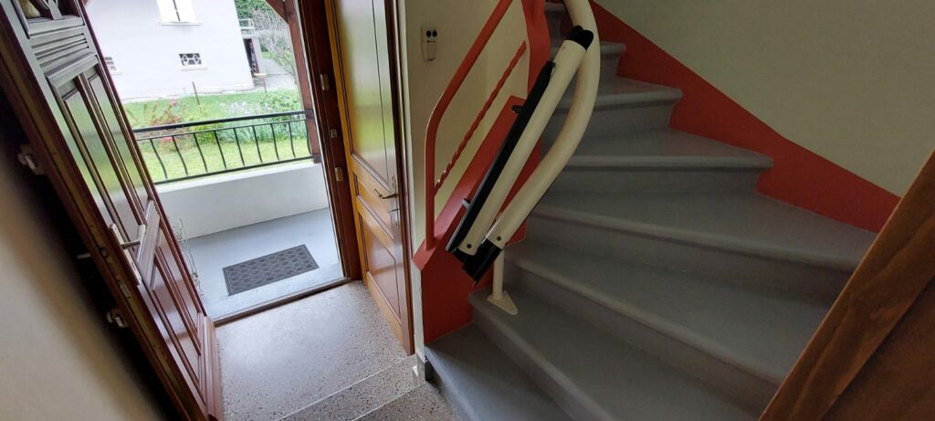 Monte-escalier replié en bas d'escalier rouge et gris près d'une porte d'entrée