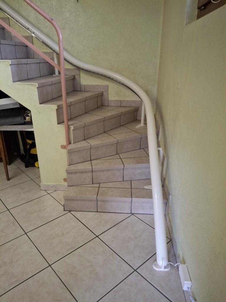 Monte-escalier installé sur un escalier courbe carrelé